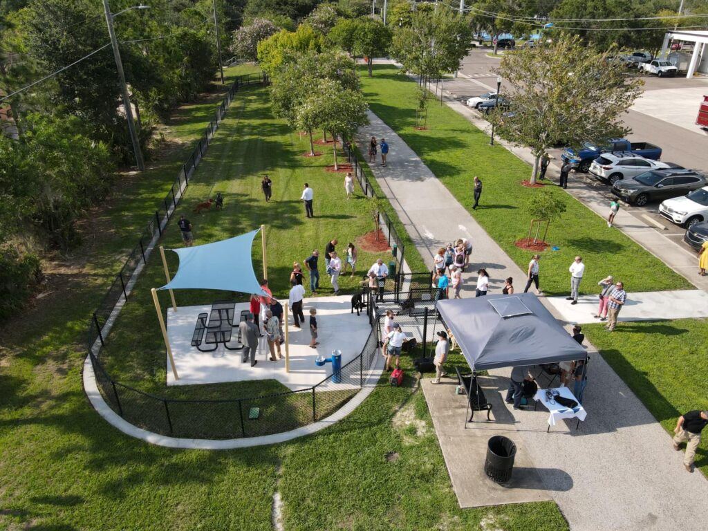 A view from an overhead drone showing people mingling around the entrance of the downtown dog park.